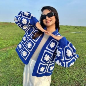 Royal blue granny square crochet jacket with white flower motifs and puff sleeves